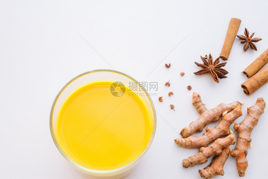 消炎药白桌底面杯子中的黄色饮料有机的卷曲米根和香料健康食品平板玻璃有复制空间健康食品印度人配料图片