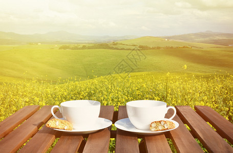 复古的木制桌上两个咖啡杯和罐子意大利托斯卡纳风景爬坡道杯子图片