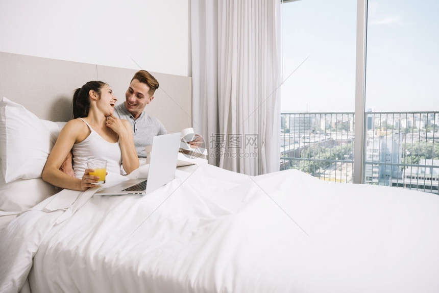 一对夫妇在清晨拥抱着欢笑的床早晨偎帅哥图片