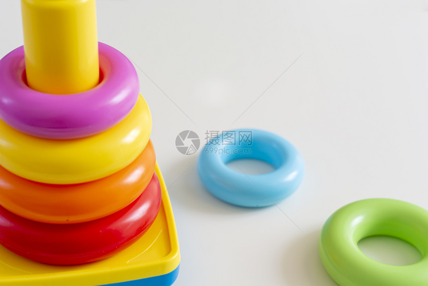 堆在塔楼的多彩塑料环为新生儿准备玩具蓝色的游戏时间乐趣图片