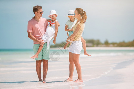 有孩子的家庭在海滩上度假的年轻家庭玩得开心极了海洋女孩男人图片