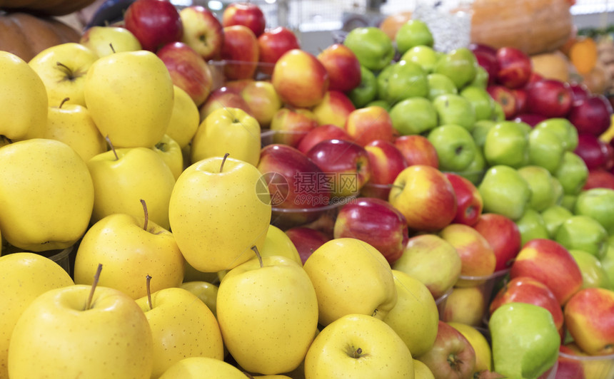 素食主义者为了鲜黄色的金苹果和其他品种的苹果在柜台上出售图片