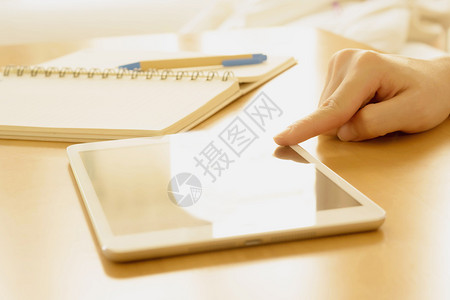 教育电子的近距离靠学生的手在家中桌子上的平板电脑搜索屏幕图片