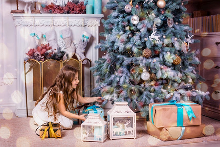 圣诞树下的小女孩拆礼物图片