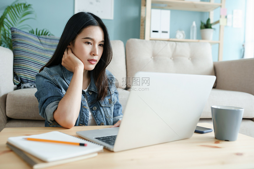 成功触碰每天早上坐在起居室的地板上时使用电脑笔记本工作的年轻女子在家中工作她很美丽互联网图片