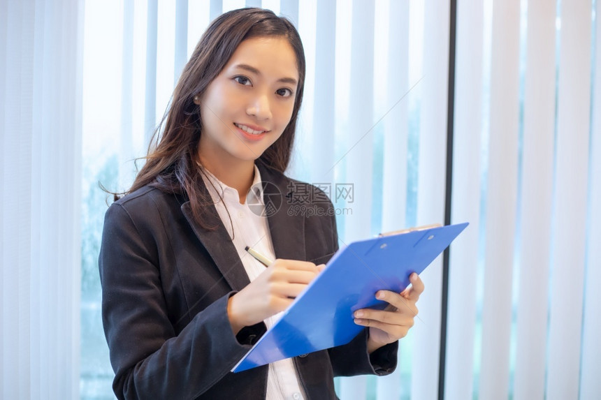 成功的亚洲商业妇女为工作和检查文件而笑着高兴的亚洲商业妇女成功桌子图片