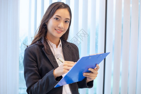 成功的亚洲商业妇女为工作和检查文件而笑着高兴的亚洲商业妇女成功桌子图片
