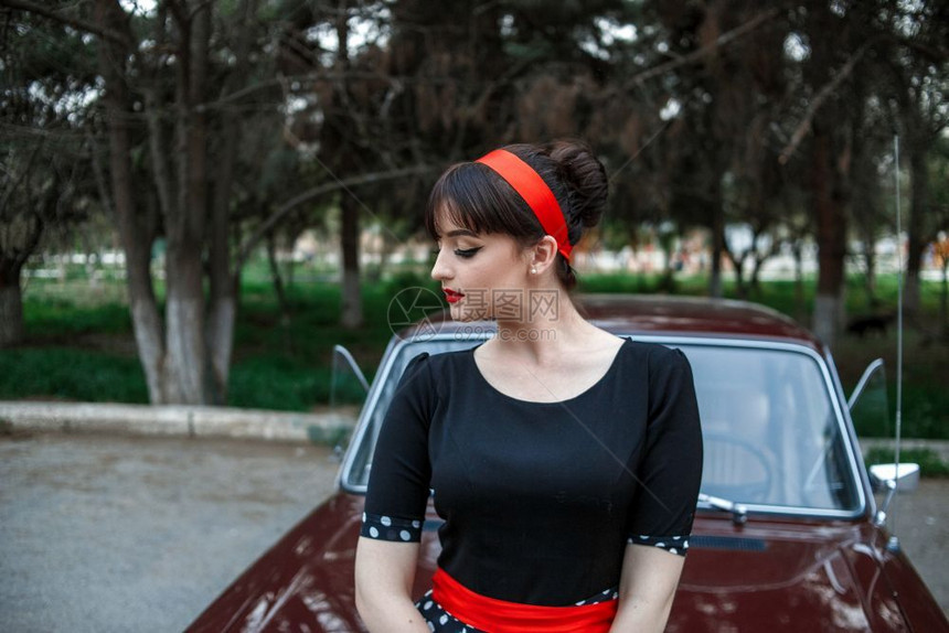 时尚女身着黑色旧礼服在一辆车旁边摆姿势的高加索美丽年轻女孩肖像图片