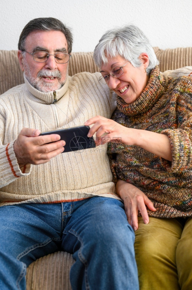 成熟Covid19待在家里快乐的退休老年夫妇用手机进行家庭视频通话社交距离积极的表达Covid19快乐的退休老年夫妇积极的表达妻图片