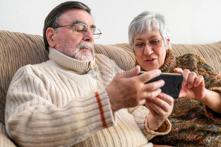 丈夫Covid19待在家里快乐的退休老年夫妇用手机进行家庭视频通话社交距离积极的表达Covid19快乐的退休老年夫妇积极的表达室图片