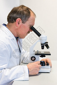研究员聚焦实验室用显微镜研究涂层的医生学习图片