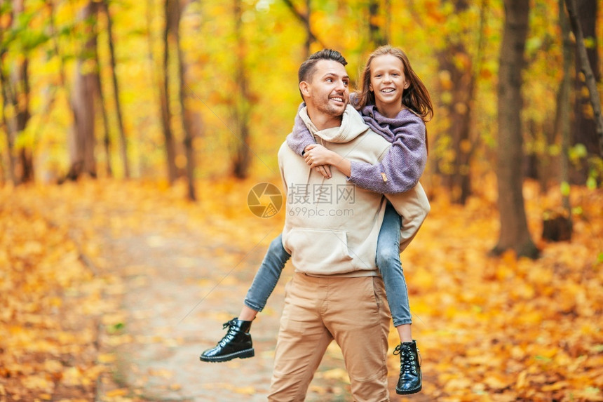 秋天公园里父亲背着女儿玩耍图片