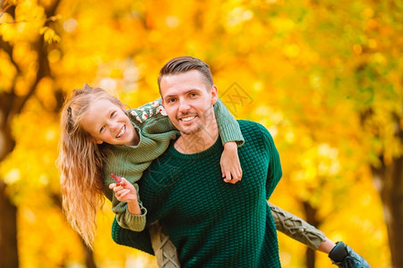 秋天公园里父亲背着女儿玩耍图片