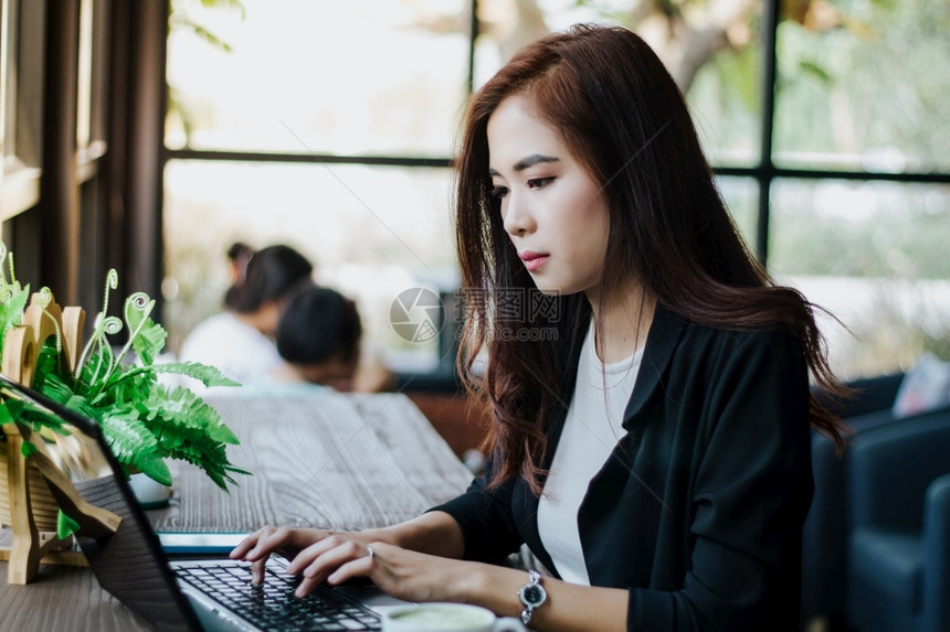 互联网在职的使用笔记本工作的亚洲商业妇女吸引人的图片