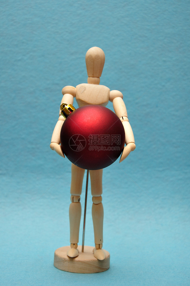 圣诞节一个木制艺术模特儿拿着红色的圣诞酒杯玩具人体模型图片
