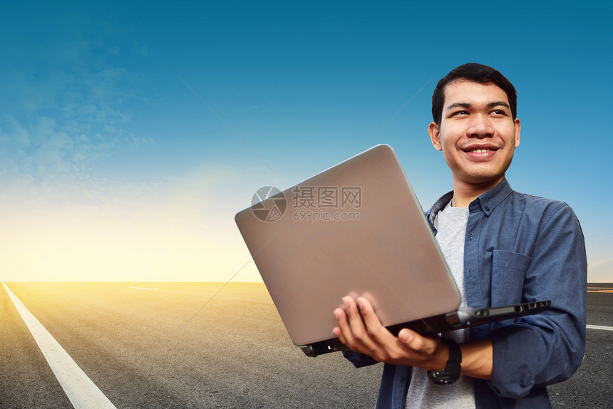 亚洲男子持有公路背景电脑笔记本拥有无线计算机技术笔记本承包商男人互联网图片