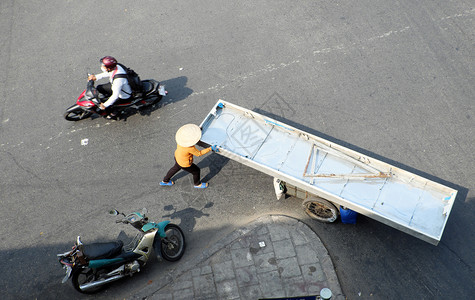 豪在越南胡志明市的街上女铁商在车边推着长片子汽车流通图片
