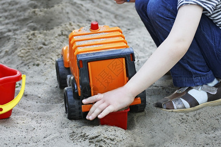 小孩沙滩上玩玩具车图片