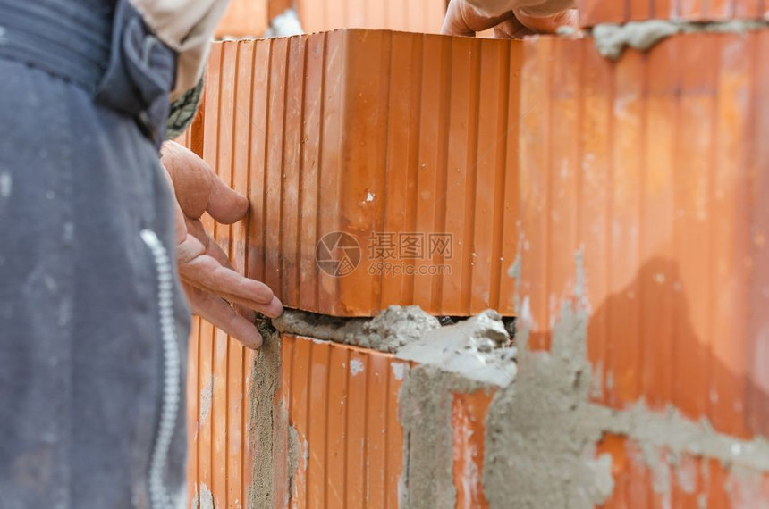 工业地水泥砖块和建筑墙铺设工地手调整砖瓦的详情在工业地铺筑泥砖块和建墙专业的瓦工家图片