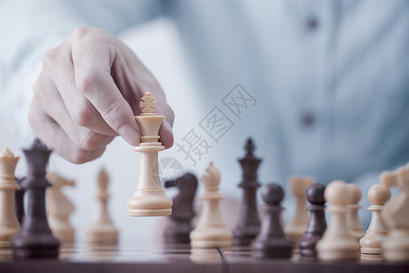 风险商人在竞争成功游戏概念战略和成功管理或领导方面玩象棋游戏并成功管理或领导才能赢挑战背景图片
