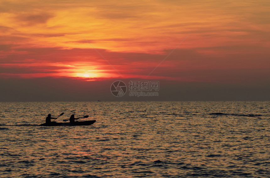 闲暇轮廓夫妇的休在海中乘皮艇日落是在热带海边的日落Kayak日落是罗曼情侣在暑假旅行浪漫情侣冒险活动美丽的夕阳天空漂浮图片