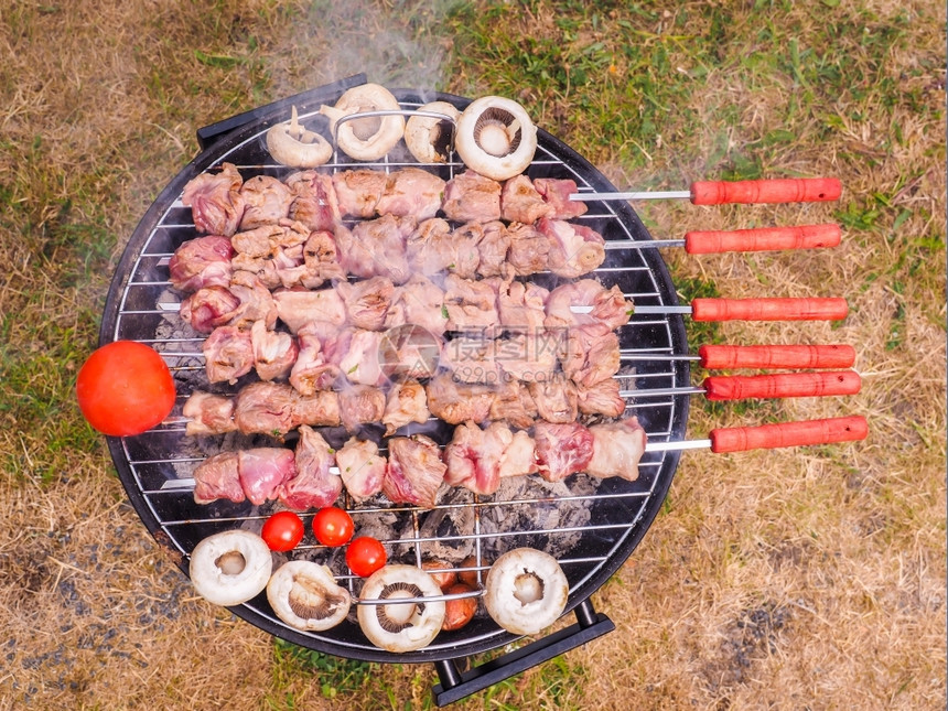 黑圆木炭烧烤室外的黑圆形木炭烤肉嘘坎皮尼翁烹饪图片