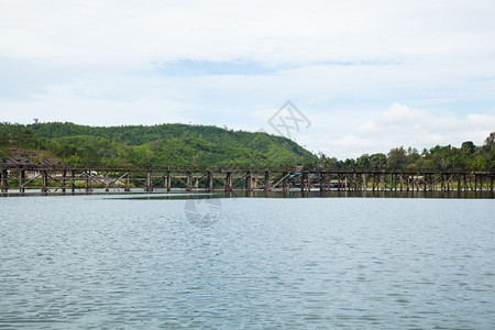 木头建造横跨河流的木环桥背面和河两边的山峰流动图片