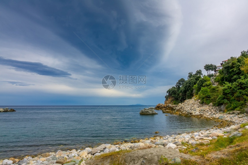 日出希腊夏季海景空岸和一座小别墅在绿树中夜边海湾和戏剧天空的叶子图片