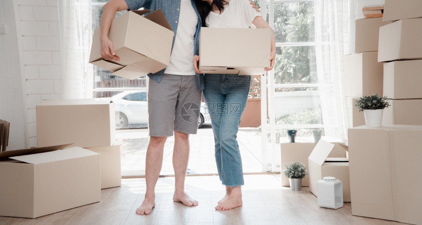 幸福的年轻夫妇携带纸板盒站在新房子前门移动日的新房门口搬家概念租房和屋主搬家新的天成功图片
