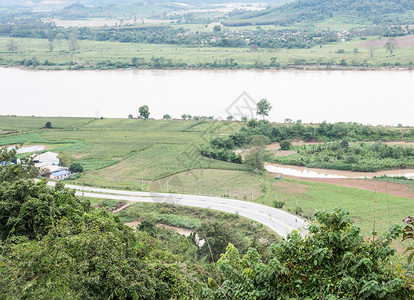 超过车沿大河绕泰国农村场以北的大河修筑沥青路段季节图片