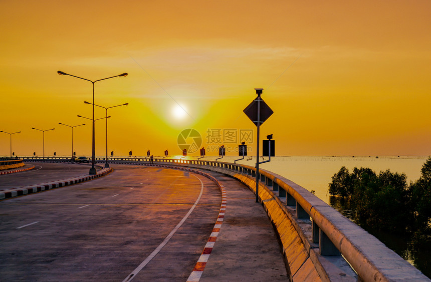 极具体的在泰国春布里日落时用街灯和橙色天空绕过沿海公路以街道灯和橙色天空包围沿海公路城市图片