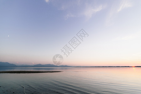 安宁山相同的在巴伐利亚湖中日落与月和太阳同时交汇的天文结合背景图片