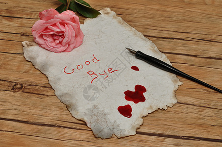 一张用旧喷泉笔和一朵粉红玫瑰涂满血迹的旧纸上遗书花悲伤背景