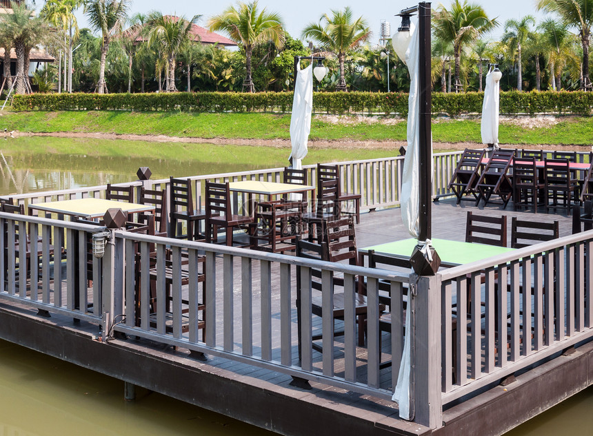 河在小池塘的木阳台上有当地餐馆的桌子套景观夏天图片