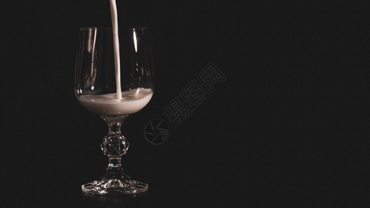相机活力降低透明的葡萄酒杯装满黑色背景的奶粉Name图片