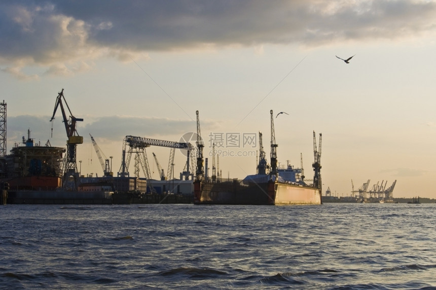 大气层货物日落时在汉堡的Elbe码头边图片