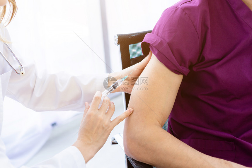 女医生用注射器给病人治疗特写图片