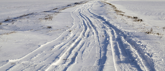 街道降雪地里的路冬天近处路边到达的汽车辙雪地里路没有清理干净线图片