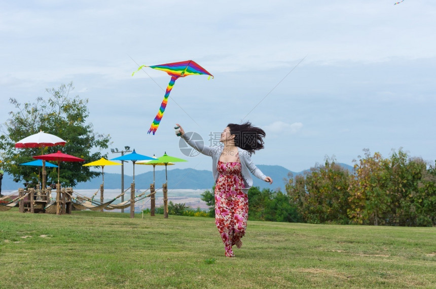 妇女穿着红礼服在明日与风筝一起欢乐跑夏天红色的图片