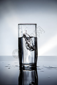 酒精以冰水浇灌的透明玻璃杯浇注瓶子图片