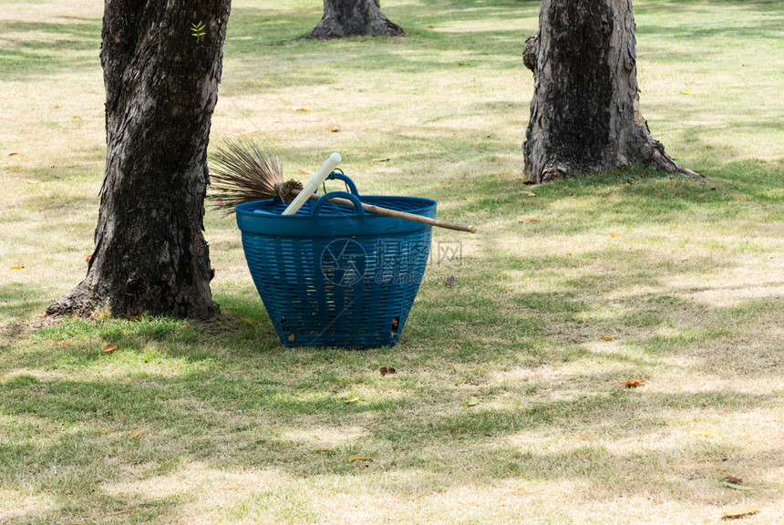 放城市的干净公园丁扫帚和塑料篮图片