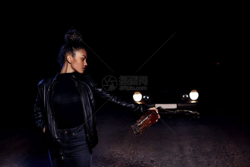 悲伤郁闷分手身穿皮夹克和黑衣服的非洲醉酒美国女孩穆拉托AfricandruntMulatto穿着皮夹克与黑衣的女孩在一条废弃的沙图片