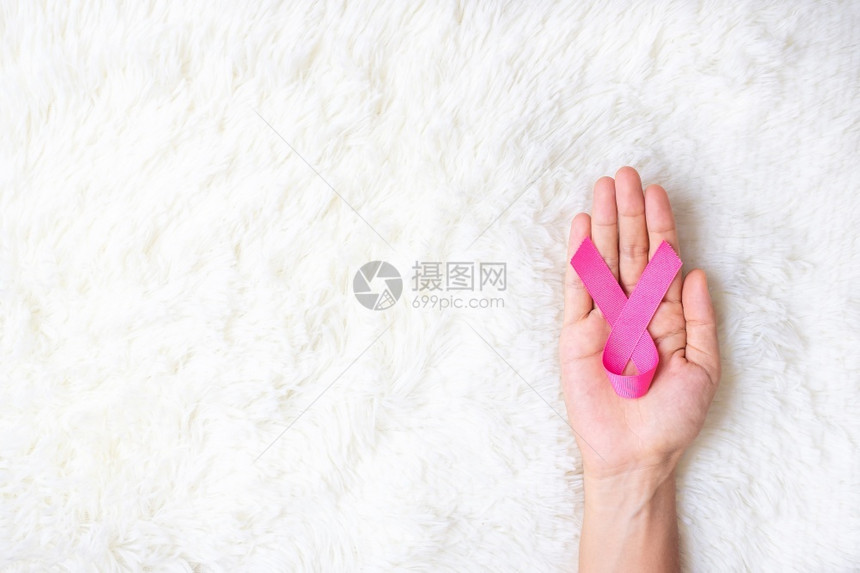 手捧粉色丝带预防乳腺癌概念图片