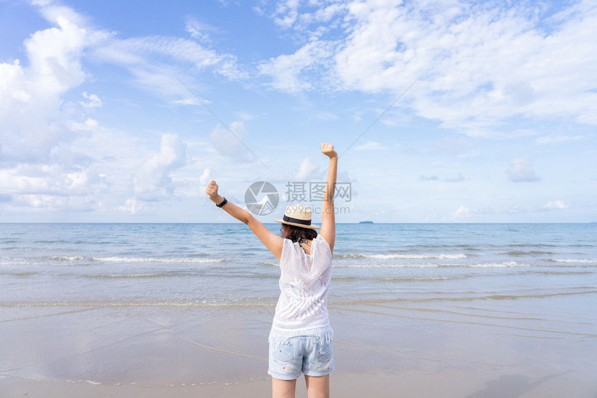 放松常设年轻亚洲女穿着时装帽子和服站在海滩上享受着暑假时蓝天的海景风与蓝色天空的外出夏月肖像蓝色的图片