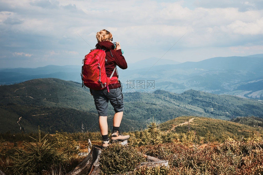 渡过与自然相近的暑假在山顶欣喜地风景全的树桩上站立着女人的后视线在大自然附近度过暑假运动开支远足图片