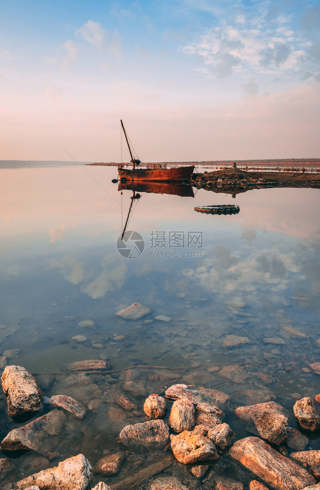 途径夏季日落时湖和旧船的全景日落时盐湖的全景日落时绿色库亚尔尼克图片