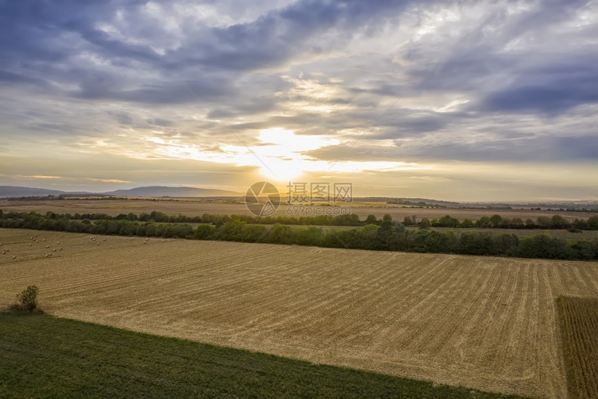 农村日落时从无人驾驶飞机到农田的空中观察稻草落下图片