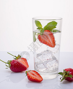 液体鸡尾酒含柠檬和薄荷的草莓水含冷冻在冰块中的水果矿物太阳图片