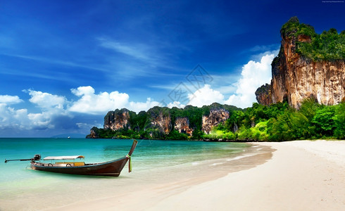热带阿伦日落泰国Krabi绿水中的长尾船图片