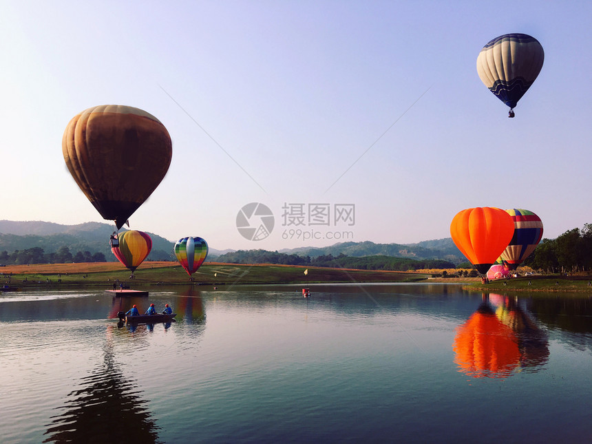 飞过河流的多彩热气球图片